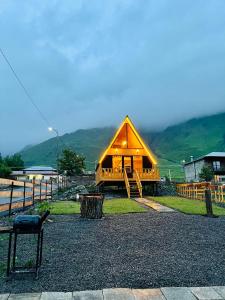 a large wooden cabin with a mountain in the background at Cottage Carpe Diem in Stepantsminda