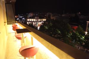 a balcony with a view of a city at night at Apartment No 5 in Prishtinë
