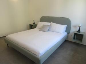 a bed with white sheets and pillows in a bedroom at Make a wish - near the center with private parking in Como