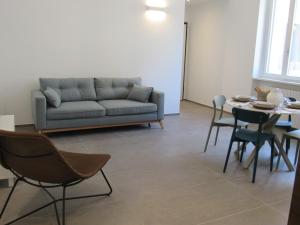 ein Wohnzimmer mit einem Sofa, einem Tisch und Stühlen in der Unterkunft Make a wish - near the center with private parking in Como