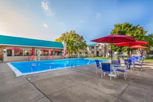 a pool with tables and chairs and umbrellas at Cayuga Blu in Ithaca