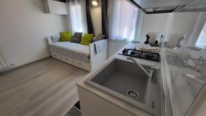 uma cozinha com um lavatório e um sofá num quarto em Casa lagunare haus em Chioggia