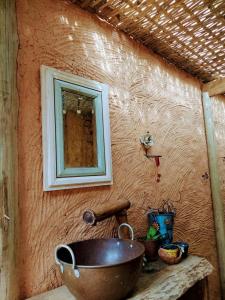 a sink in a house with a mirror on the wall at Pousada Bangalô de Barro in Paraty