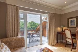 uma sala de estar com uma porta de vidro deslizante que leva a uma varanda em Court Yard Hotel em Leixlip