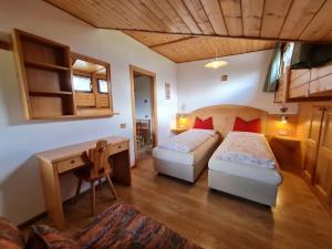 ein Hotelzimmer mit 2 Betten, einem Schreibtisch und einem Schreibtisch in der Unterkunft Piccola Suite sul Civetta in Colle Santa Lucia