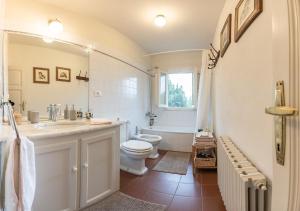 een badkamer met een toilet, een wastafel en een bad bij La Dimora di Corte a Lucca in Lucca