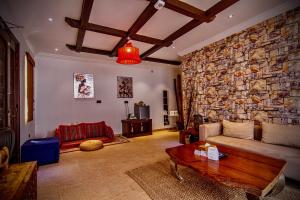 salon z kamienną ścianą i kanapą w obiekcie Coastline Resort w mieście Al-Masna’a
