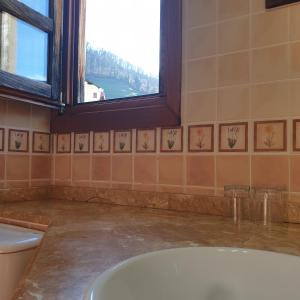 a bathroom with a tub and a window at La Pumarada de Limés I in Cangas del Narcea