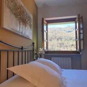 um quarto com uma cama e uma grande janela em La Pumarada de Limés I em Cangas del Narcea