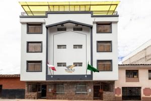 a large white building with flags on it at Hotel Wayra Dreams in Cusco