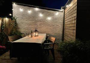 a dining table with lights on a patio at night at Characteristic ground floor apartment with box bed in Groningen