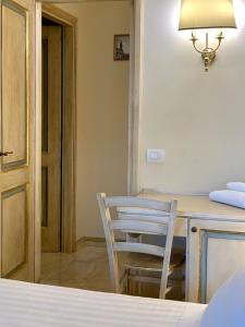 um quarto com uma mesa, uma cadeira e um candeeiro em Fifty Eight Suite Milan Larga em Milão