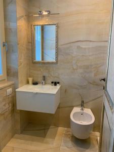 uma casa de banho com um lavatório branco e um espelho. em Fifty Eight Suite Milan Larga em Milão