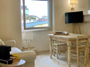 a living room with a table and a tv at Fifty Eight Suite Milan Duomo View in Milan