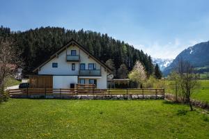 ein Haus auf einem Feld mit Bergen im Hintergrund in der Unterkunft Aberle Apartments in Rossleithen