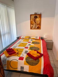 a bedroom with a bed with a colorful quilt on it at Apartment Locarno-Lido in Locarno