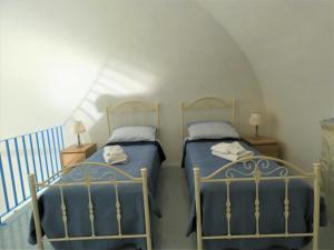 duas camas num quarto com uma escada em House Sasanelli em Bari