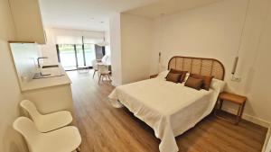 a bedroom with a bed and a table and chairs at BR Silgar Suites in Sanxenxo