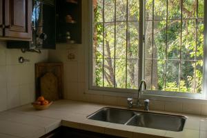 un fregadero con ventana y un bol de fruta en Casa de campo La Brea en San Fernando del Valle de Catamarca