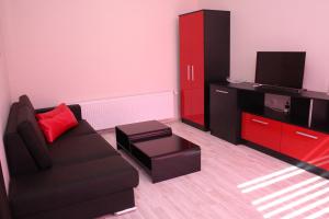 a living room with a black couch and a red cabinet at Incanto Family Hotel in Sevlievo