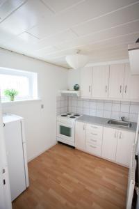 a white kitchen with a sink and a stove at Lovely 2- bedroom apartment in central Tórshavn in Tórshavn