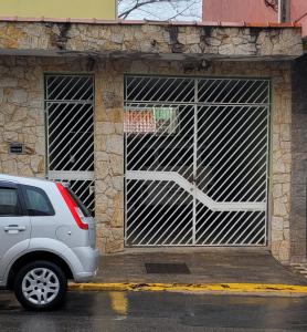 a car parked in front of a garage at Aconchego Sagrada Face in Aparecida