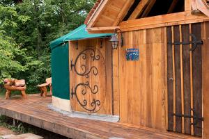 a wooden out house with a bench on a deck at Yourte La Désirade in Semur-en-Auxois