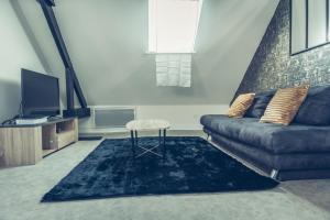 - un salon avec un canapé et un tabouret dans l'établissement Le loft superbe studio avec stationnement gratuit, à Dunkerque