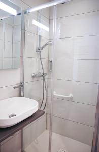 uma casa de banho com um chuveiro e um lavatório. em HOTEL AMBASSADEUR em Lille
