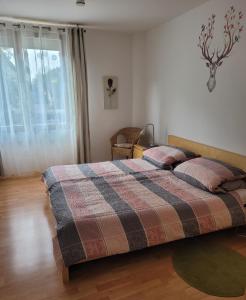 una camera da letto con un letto con una coperta scozzese e una finestra di Ferienwohnung Burgblick a Wiesbaden