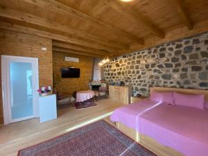 a bedroom with a bed and a stone wall at Bianca Hotel & Villa in Tirana