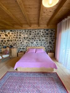 a bedroom with a bed in a room with a stone wall at Bianca Hotel & Villa in Tirana