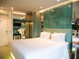 um quarto com uma cama branca e uma parede verde em WC by The Beautique Hotels em Lisboa