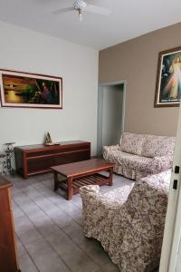 a living room with a couch and a coffee table at Aconchego Sagrada Face in Aparecida