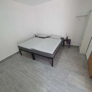 a bed sitting in a room next to a wall at Budget Apartment LeLo Center 4 in Osijek