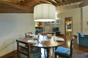 a dining room with a wooden table and chairs at Tiepolo romantic penthouse in the Oltrarno in Florence