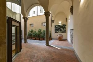 an empty hallway of a building with columns at Tiepolo romantic penthouse in the Oltrarno in Florence