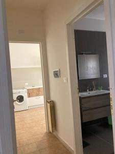 a kitchen with a sink and a microwave at La Ginestra Apartment in Marsala +8 photos