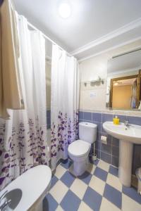 łazienka z toaletą i umywalką w obiekcie Apartahotel Trébede w mieście Barro de Llanes