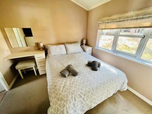 a bedroom with a bed with two teddy bears on it at Waterfall Retreat in Poole