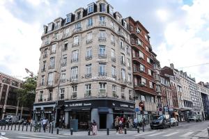 a large building on the corner of a city street at HOTEL AMBASSADEUR in Lille