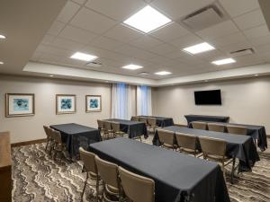 a room with tables and chairs and a flat screen tv at Staybridge Suites - Sioux City Southeast, an IHG Hotel in Sioux City