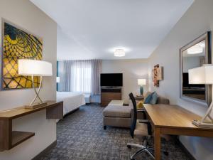 a hotel room with a bed and a desk at Staybridge Suites - Sioux City Southeast by IHG in Sioux City