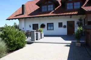 une maison blanche avec une passerelle en briques devant elle dans l'établissement Gästehaus Fechtig, à Hergensweiler
