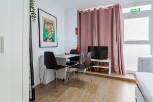 Pokój ze stołem, krzesłami i różową zasłoną w obiekcie ApartEasy - Goya Ground Floor Studio w Madrycie