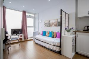 sypialnia z łóżkiem z kolorowymi poduszkami w obiekcie ApartEasy - Goya Ground Floor Studio w Madrycie