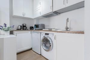 Biała kuchnia z pralką i zlewem w obiekcie ApartEasy - Goya Ground Floor Studio w Madrycie