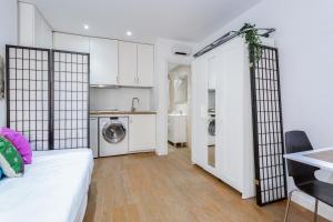Pokój z łóżkiem i kuchnią z pralką w obiekcie ApartEasy - Goya Ground Floor Studio w Madrycie