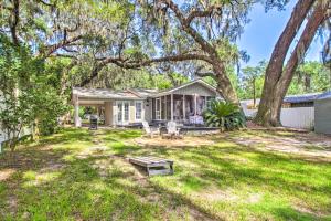 ein Haus mit einem großen Baum im Hof in der Unterkunft The River Cottage Charming Retreat with Dock in Midway
