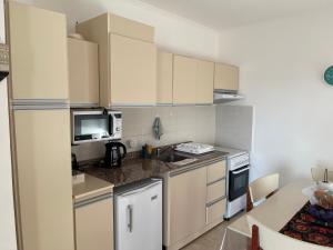 a kitchen with white cabinets and a sink and a microwave at Edif Montecarlo I En PB, a mts de las Termas in Federación +18 photos
